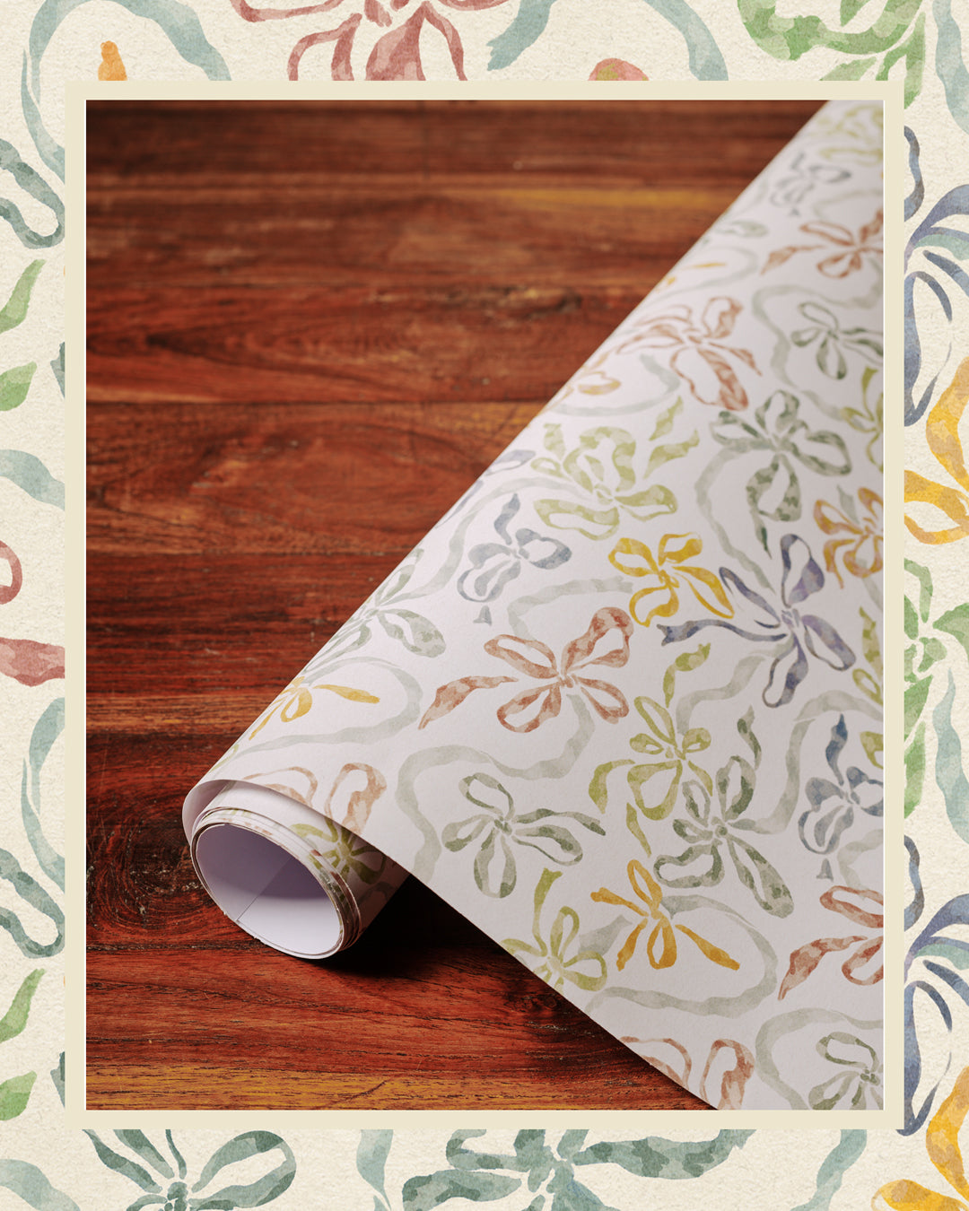 A rolled-up piece of paper with a bow pattern, presumably part of a larger sheet, placed on a wooden surface with a decorative border around the image.