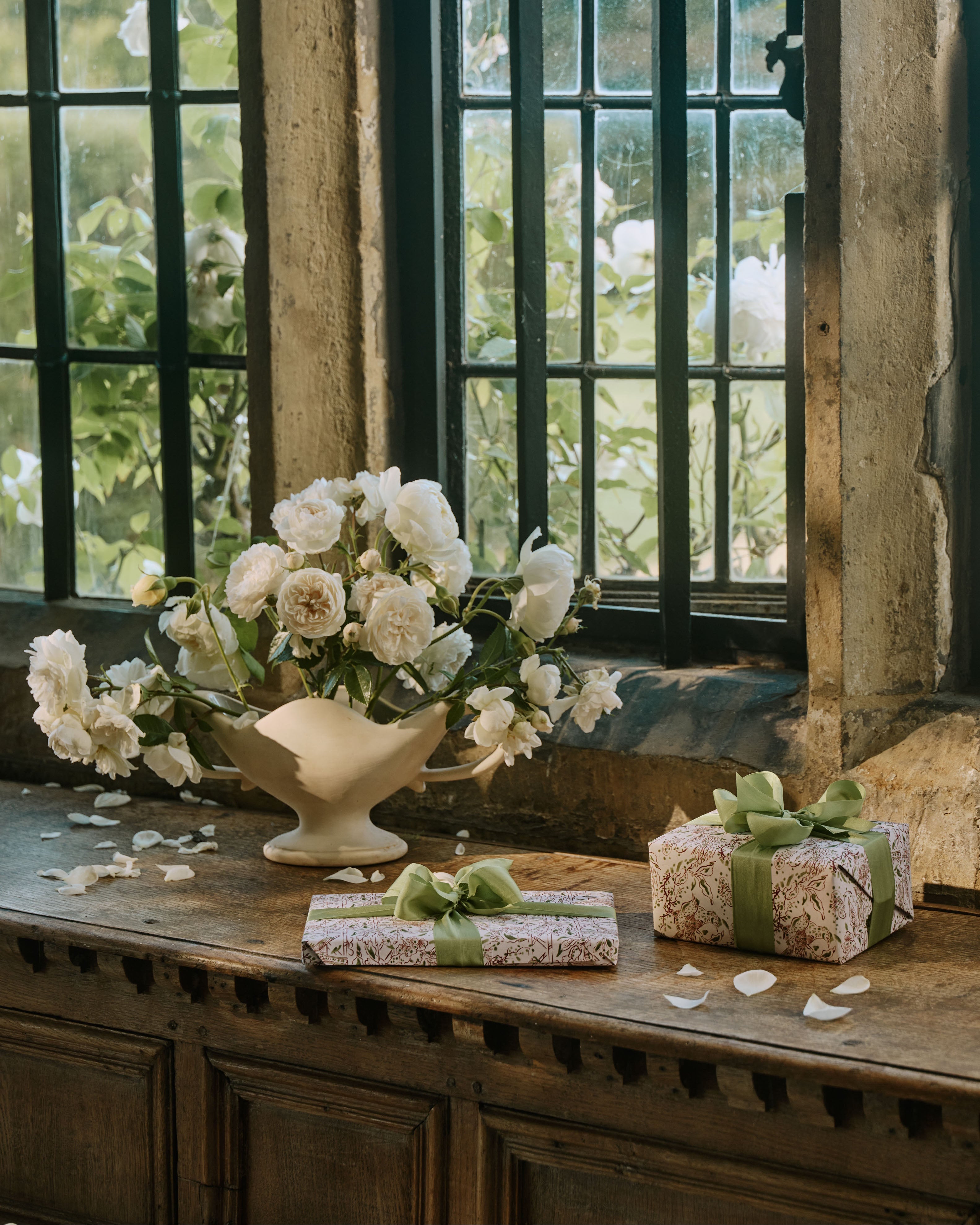 Gifts wrapped in The Kensington Paperie wrapping paper on a window ledge at Ashby Manor House.