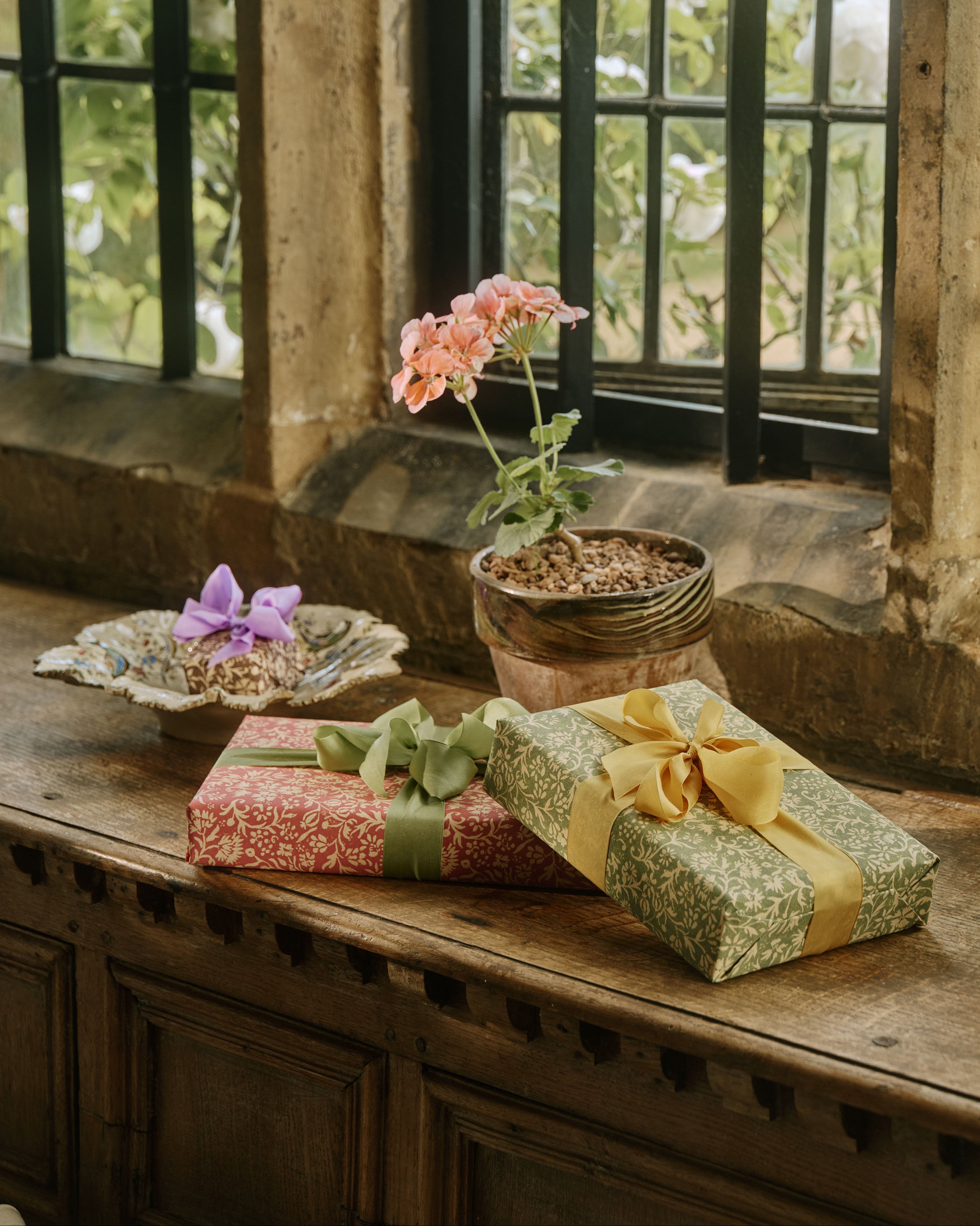 Gifts wrapped in The Kensington Paperie wrapping paper on a window ledge at Ashby Manor House.